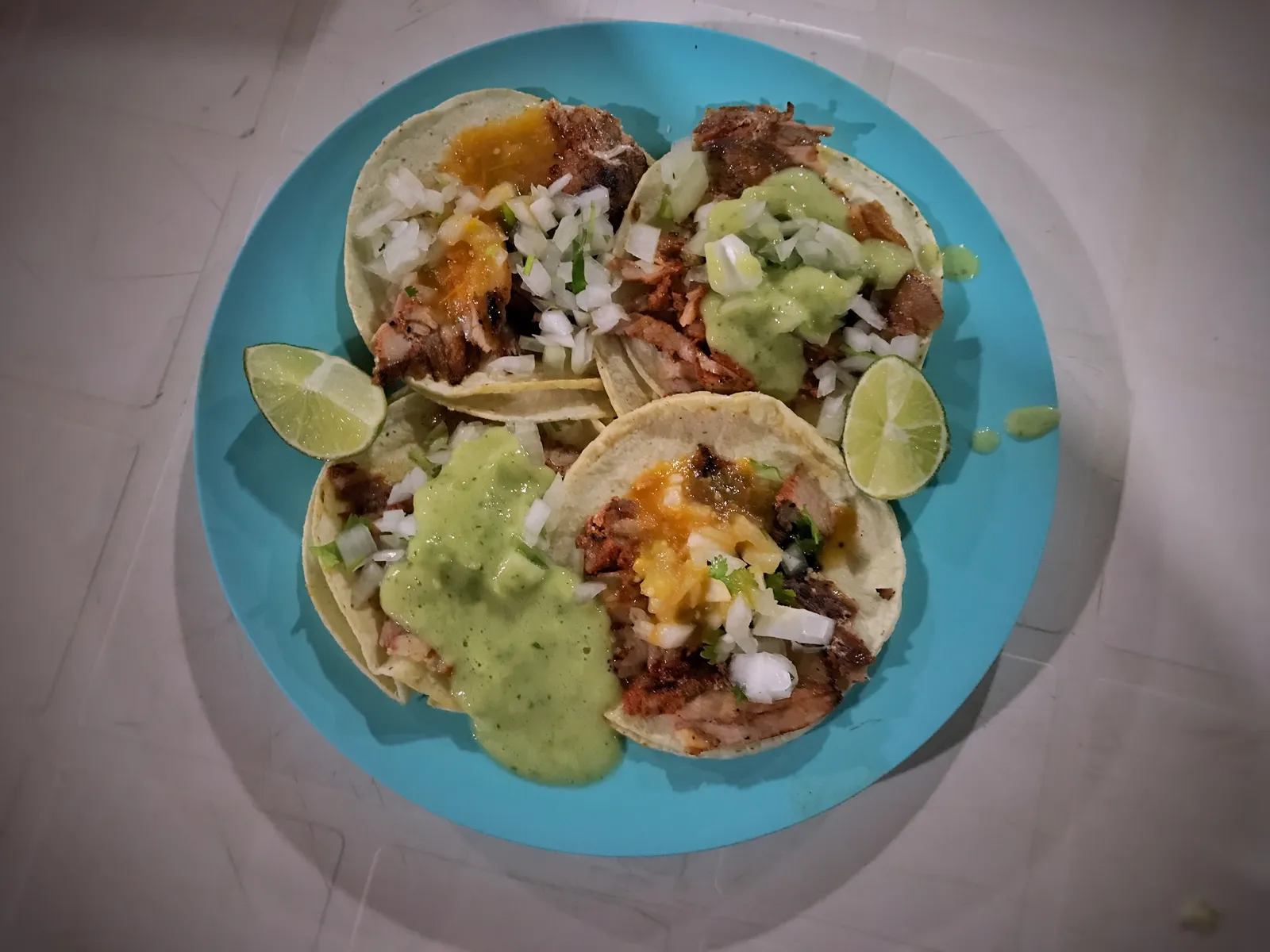 A plate of al pastor tacos with onion, cilantro, salsa and lime. The photo was not taken at a Peachtree City restaurant.
